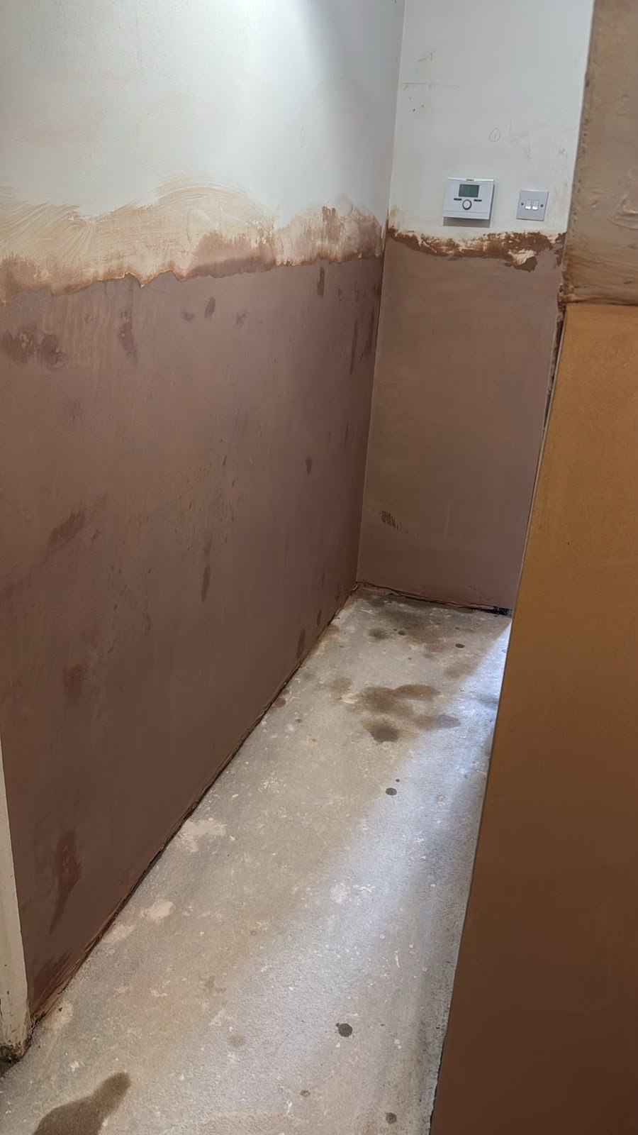 Plastered walls and screeded floor at the agreed handover stage, ready for the owners to decorate.