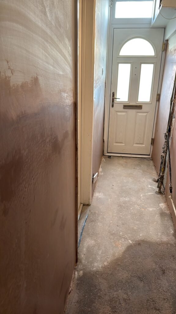 The corridor after waterproofing and plastering, with decoration still to follow.