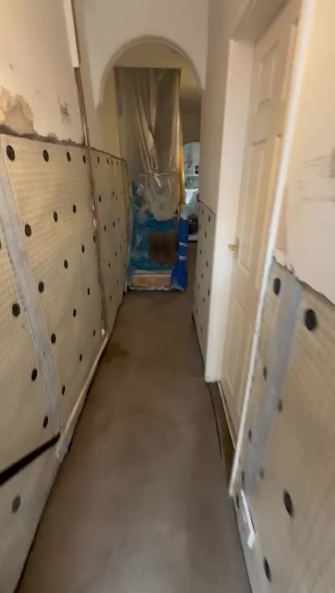 Cavity drain membrane installed along the corridor before plastering.